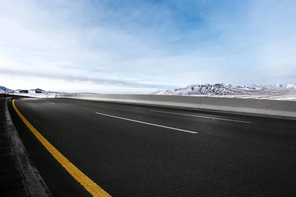 雪山と空のアスファルト道路 — ストック写真