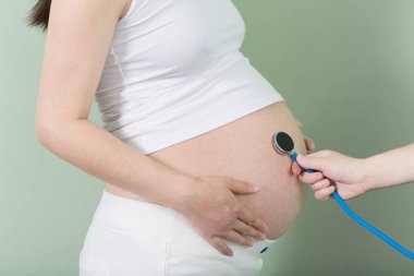 hamile kadının göbek ve stetoskop