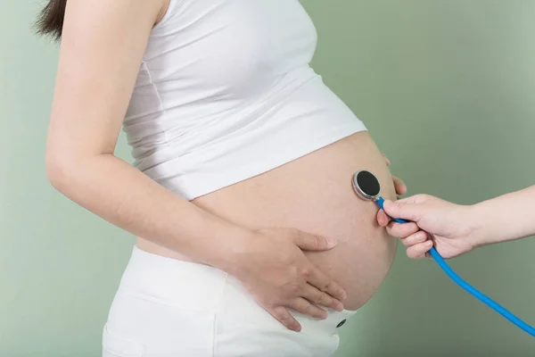 Vientre y estetoscopio de la mujer embarazada — Foto de Stock