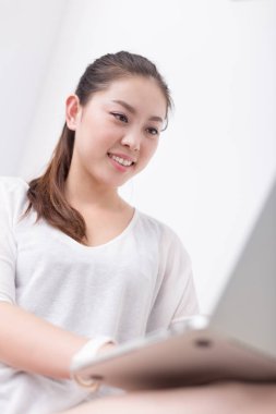 güzel kadın kanepede dizüstü bilgisayar kullanarak