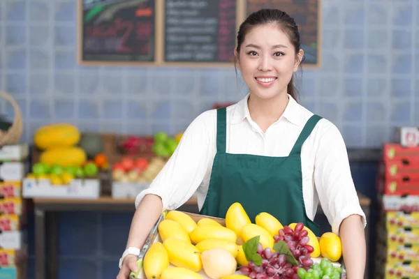 Pretty woman works in fruit store — Stock Photo, Image