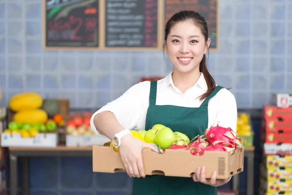 Pretty woman works in fruit store — Stock Photo, Image