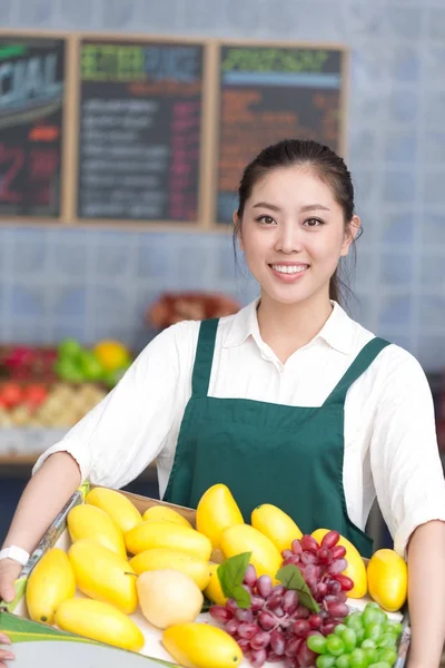 Pretty woman works in fruit store — Stock Photo, Image