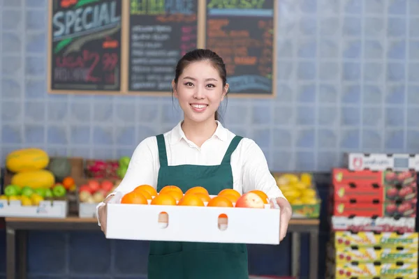 pretty woman works in fruit store