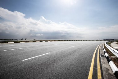 Mavi güneşli bulut gökyüzünde boş kırsal asfalt yol