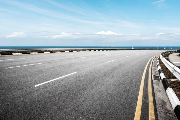 Пустая Асфальтовая Дорога Синее Море Голубом Небе — стоковое фото