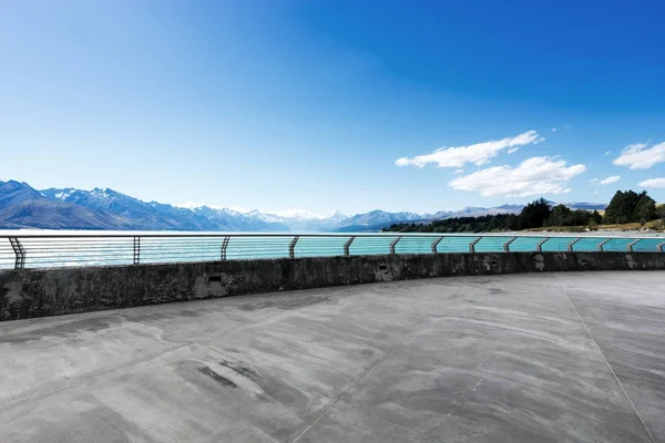 空のコンクリート道路と青空の美しい湖 — ストック写真