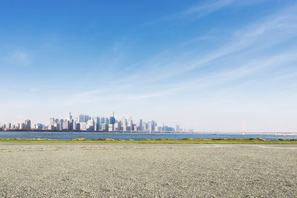 Empty grounds with cityscape near water — Stock Photo, Image