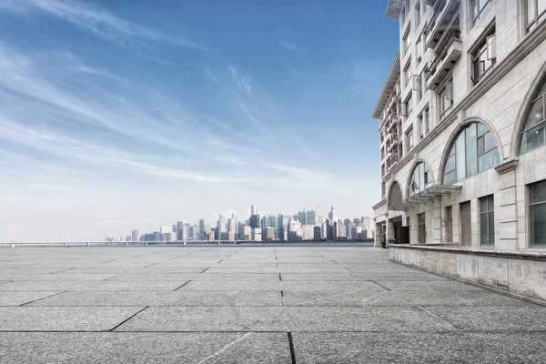 Pavimento di marmo vuoto vicino all'acqua con paesaggio urbano — Foto Stock