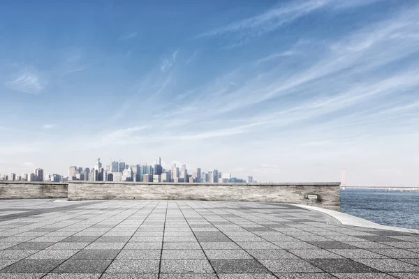 Empty marble floor near water with cityscape — Stock Photo, Image