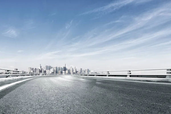 Empty road with cityscape near water — Stock Photo, Image