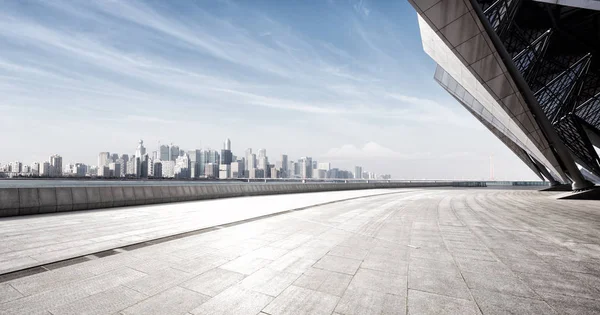 Pavimento di marmo vuoto vicino all'acqua con paesaggio urbano — Foto Stock