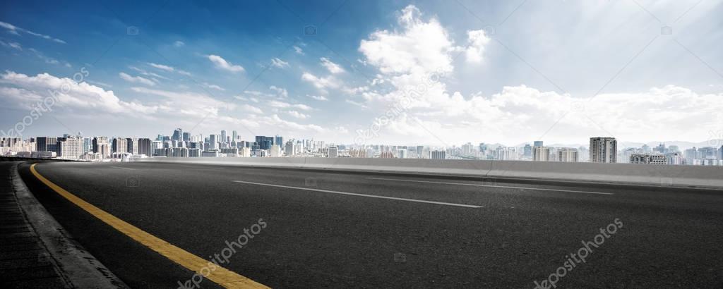 empty asphalt road with cityscape of Hangzhou in cloud sky