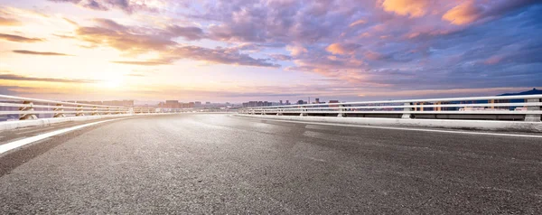 empty asphalt road with cityscape of Hangzhou in colorful cloud sky