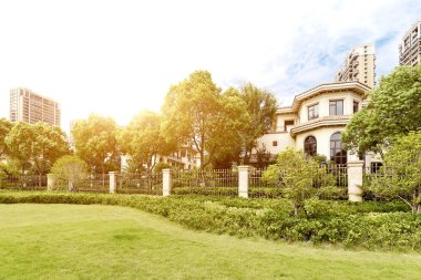 güneş ışığı altında Hangzhou modern bir yerleşim bölgesi yakınındaki güzel çayır