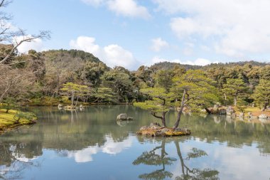 Sakin su ve yeşil tepeler ve mavi gökyüzü güzel yansıması