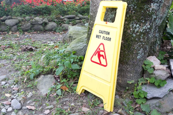 yellow plastic wet floor sign on ground