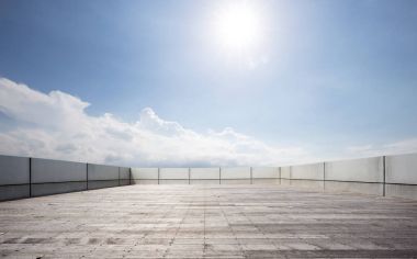 mavi gökyüzünde beton duvarla çevrili boş tuğla zemin