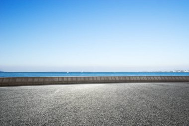 boş kırsal asfalt yol ve mavi denizde mavi gökyüzü