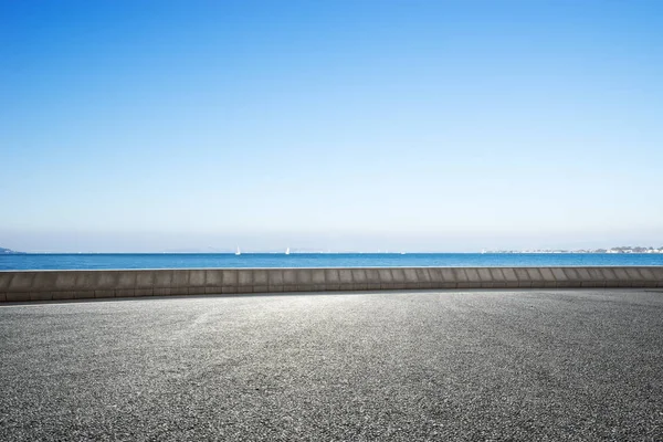 boş kırsal asfalt yol ve mavi denizde mavi gökyüzü