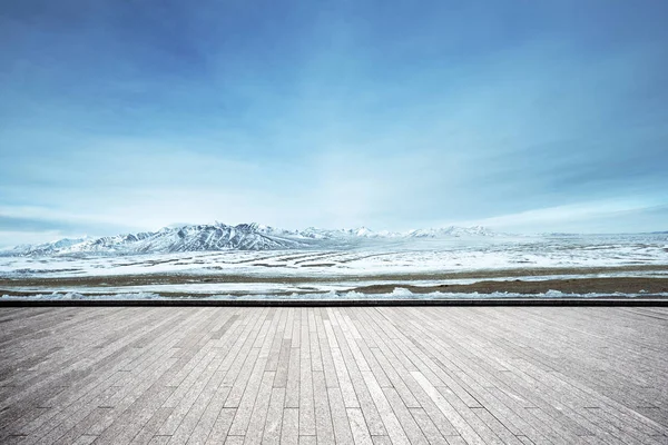 空レンガ床と雪の山中空青い雲 — ストック写真