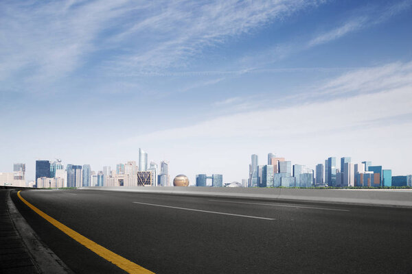 Empty asphalt road and cityscape of Hangzhou Qianjiang new city in blue cloud sky