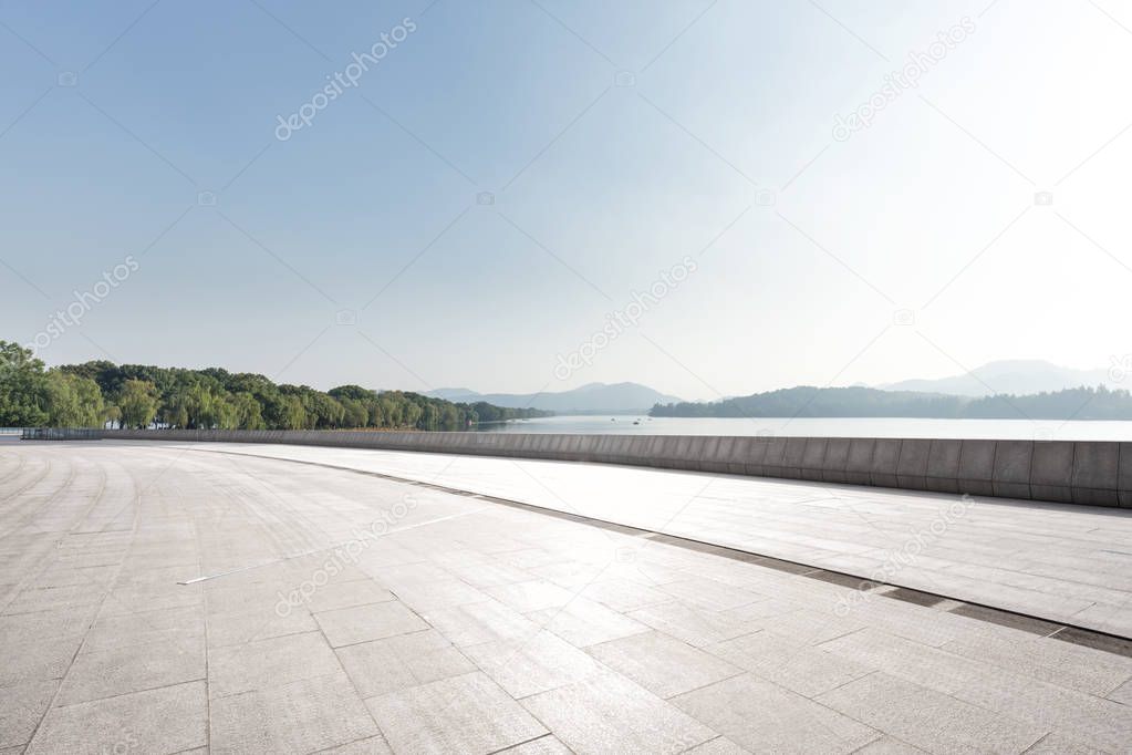 empty marble floor and beautiful lake in blue sunny sky