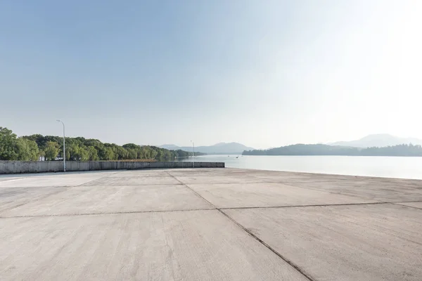 Lege Betonnen Vloer Prachtige Lake Blauwe Zonnige Hemel — Stockfoto