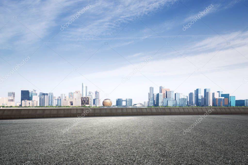 empty asphalt road and cityscape of Hangzhou Qianjiang new city in blue cloud sky