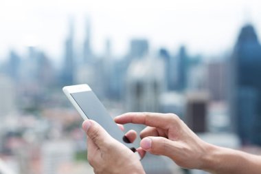 adam cep telefonu ile balkon Kuala Lumpur merkezinde üzerinde çalış