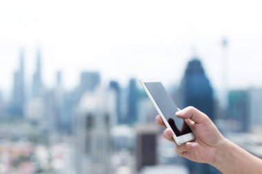 adam cep telefonu ile balkon Kuala Lumpur merkezinde üzerinde çalış