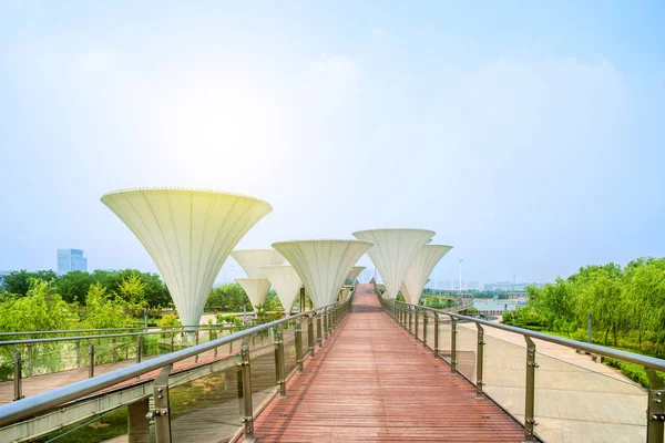 a wooden platform bridge and white mushroom shaped giant lamps