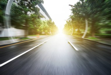 arka plan olarak gökdelenler ile modern bir şehir, asfalt yolu