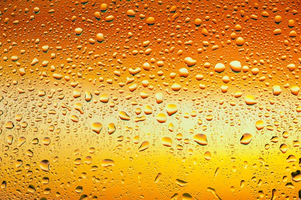 Textura abstracta. Gotas de agua sobre vidrio con fondo naranja — Foto de Stock