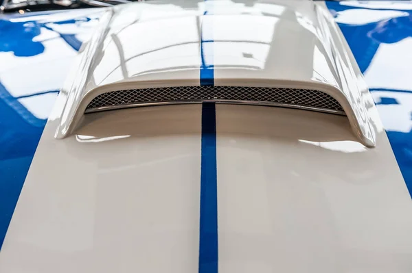 Capucha de un coche deportivo azul y blanco — Foto de Stock