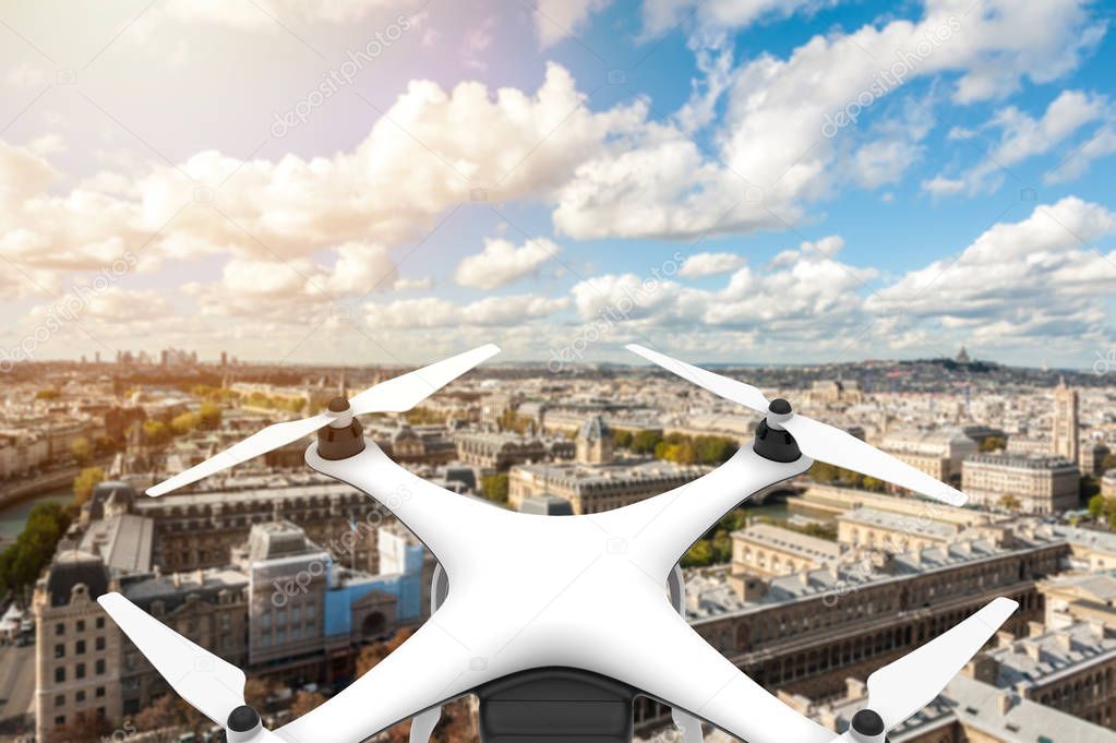 Drone with digital camera flying over a city with blue sky