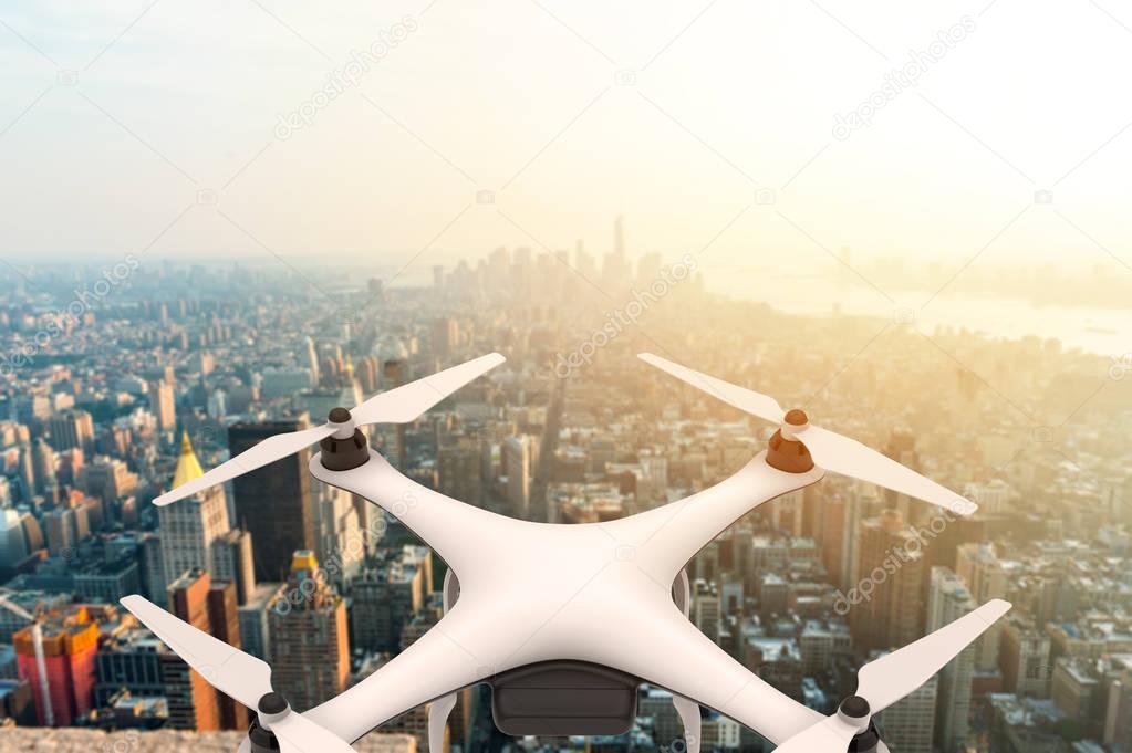 Drone with digital camera flying over a modern city at sunset