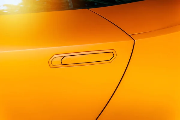 Car door handle of an orange modern car — Stock Photo, Image