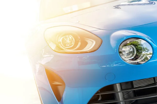 Frente a un coche deportivo azul en la luz del atardecer —  Fotos de Stock