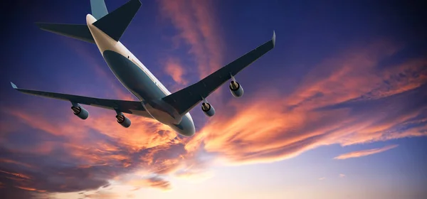 Avión volando en un atardecer nublado — Foto de Stock