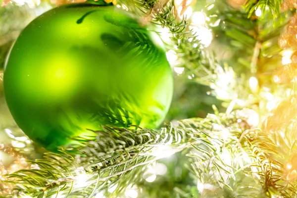 Bola verde brilhante Natal pendurado em ramos de pinho com fundo festivo — Fotografia de Stock