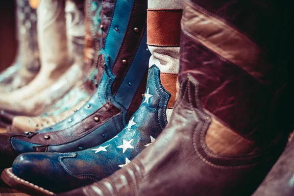 Cowboys laarzen op een plank in een winkel met Usa vlag — Stockfoto