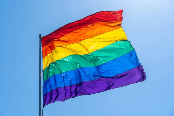 Rainbow gay pride flag on a blue sky — Stock Photo, Image