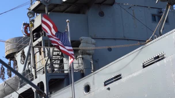 Bandera de EE.UU. ondeando al viento frente a un barco militar, cámara lenta — Vídeo de stock