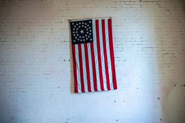 Bandeira velha dos EUA em uma parede de tijolo branco — Fotografia de Stock