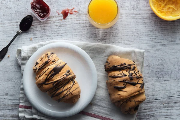 Croissant fresco com esmalte de chocolate no café da manhã — Fotografia de Stock