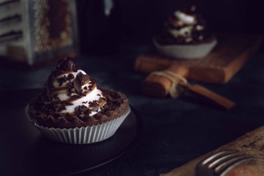 Koyu arkaplanda kremalı ve kirazlı çikolatalı kurabiye