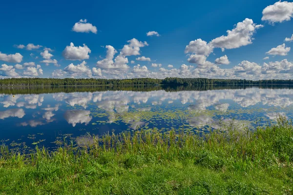 Lago com nuvens e reflexos do céu — Fotografia de Stock