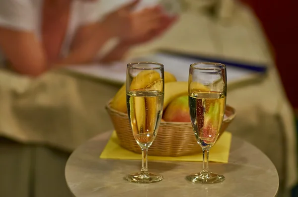 Two glasses of sparkling wine in hotel room with woman in background — Stock Photo, Image