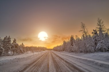 Finlandiya'da yol üzerinde kutup gece günbatımı